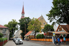 Blick in die Straße Nikolai - Restaurant mit Aussengastronomie - Kirchturm / Kirchenschiff der Elisabeth-Kirche in Pärnu; geweiht 1750.