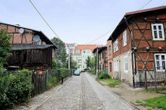 Wohnstraße mit Kopfsteinpflaster in Toruń; historische Bebauung mit Fachwerkgebäuden.