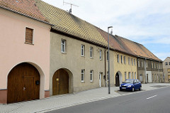 Wohnhäuser mit halbrunden Toreinfahrten, geschlossene Wohnbebauung - Straße in Schildau.