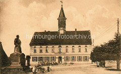 Historische Ansicht vom Rathaus in Schildau - lks. das alte Gneisenaudenkmal.