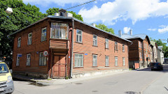 Alte Holzhäuser - traditionelle Holzarchitektur in der Straße Wismari in Tallinn - Erker mit großem Glasfenster, verriegelte Eingangstür / leerstehendes Gebäude.