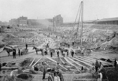 Baustelle auf dem Areal der zukünftigen Hamburger Speicherstadt - Bauarbeiter mit Pferdewagen und Handkarren transportieren den Aushub - im Hintergrund alte Wohnhäuser, re. Lagerschuppen am Sandtorhafen.