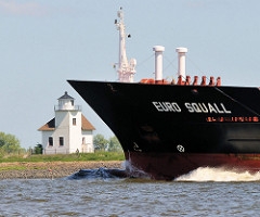 Bug des Containerschiffs EURO SQUALL in Fahrt auf der Unterelbe - die EURO SQUALL hat eine Länge von 132m und eine Breite von 19 m. Im Hintergrund das historische Gebäude des Leuchtfeuers Julesand.