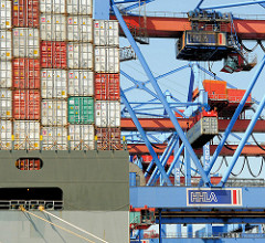 Das Containerschiff HUMAN BRIDGE wird im Hamburger Hafen abgefertigt - das Frachtschiff liegt mit seiner Containerladung unter den Containerbrücken des HHLA Terminals Burchardkai.