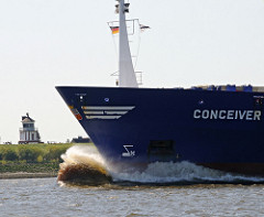 Die 1994 auf der Hambuger Sietas Werft gebaute CONCEIVER hat eine Länge von 117m und eine Ladekapazität von 547 Containern TEU. Im Hintergrund das alte Leuchtfeuer hinter dem Deich von Lühe.