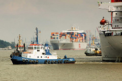 Bilder aus dem Hamburger Hafen - Schlepper ziehen einen Frachter vom Kai - Containerschiff mit Containern beladen läuft aus.