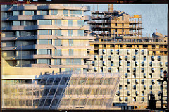 Baustelle und Hausfassaden in der Hamburger Hafencity im Morgenlicht.