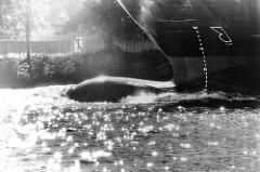 Wulstbug / Schiffsbug während der Fahrt auf der Elbe bei Hamburg - Gegenlichtaufnahme, Schwarz-Weiß.