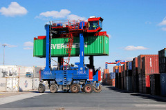 Ein Portalhubwagen / van carrier transportiert einen Container im Hamburger Hafen.