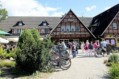 Café, Restaurant, Hotel in Undeloh - geparkte Fahrräder, Touristen während der Heideblüte.
