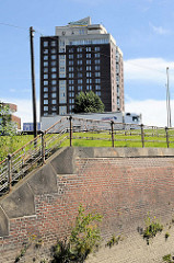 Alte Kaimauer / Ziegelsteinverblendung -  Treppenaufgang mit historischem Eisengeländer am Oberhafenkanal in Hamburg Rothenburgsort - im Hintergrund das Hotel Holiday Inn an den Elbbrücken.
