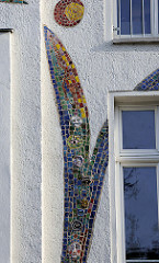 Hausfassade mit bunten Glasapplikationen / Mosaik Bänder, Entwurf Bildhauer Peter Fiedler - Haus voller Ideen in der Poststraße von Naumburg.