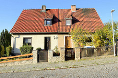 Doppelhaus mit Satteldach mit unterschiedlicher Gebäudegestaltung und Grundstücksabgrenzung in Oberweimar.