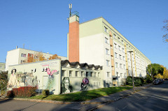 Heizwerk Dichterweg der Stadtwerke Weimar, poetische Fassadenmalerei am Zweckbau - dahinter mehrstöckige Wohnblocks.