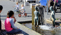 Brunnen am Untermarkt in Mühlhausen/Thüringen; zwei Skulpturen nackter Kinder stehen im Wasser - ein Eis essendes Kind sieht zu.
