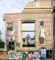 Hausruine - Restwand mit Fensterhöhle eines Gründerzeitgebäudes in Hamburg St. Pauli - die Hausfassade ist mit Veranstaltungsplakaten / Graffiti versehen.
