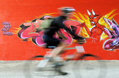 Graffiti mit Teufel - zeigt auf einen Fahrradfahrer; Fussgängerunterführung unter Wilhelmburger Reichsstraße im Hamburger Stadtteil Wilhelmsburg.