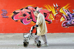 Graffiti mit Teufel - zeigt auf eine älter Frau mit Gehwagen; Fussgängerunterführung unter Wilhelmburger Reichsstraße im Hamburger Stadtteil Wilhelmsburg.