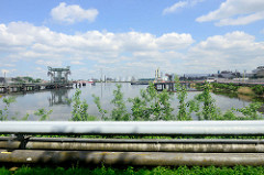 Blick auf den Kattwykhafen - Tankhafen in Hamburg Wilhelmsburg; im Vordergrund verlaufen Pipelines - im Hintergrund Tankanlagen.