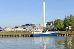 Sportboot beim Dortmund-Ems-Kanal in Münster - Brachland und Industriegebäude, stillgelegter Fabrikschornstein.