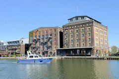 Umgenutzte alte Speichergebäude im Hafen von Münster / Kreativkai  - das Boot WSP 36 der Wasserschutzpolizei Münster in Fahrt.