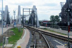 Fahrt des Museumszugs Fridolin auf den Gleisen der Hamburger Hafenbahn - Blick auf die neue Rethehubbrücke in Hamburg Wilhelmsburg.
