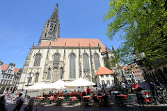 Lamberti Kirche in Münster, erbaut zwischen 1375 und 1525;  Aussengastronomie mit Tischen unter Sonnenschirmen auf dem Kirchplatz / Salzstraße.