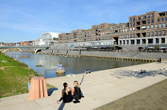 Promenade am Stadthafen von Venlo; Außengastronomie am Wasser, eine Terrassen mit Treppen zum Hafen lädt zum Sitzen ein.