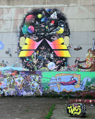 Graffiti an der Hausmauer eines alten Fabrikgebäudes im  Hafengebiet von Maastricht.