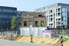 Neubaugebiet  auf einem alten Fabrikgelände am Heugemerweg  in Maastricht  - ein kleines freistehendes Gebäude im Vordergrund wird noch bewohnt.