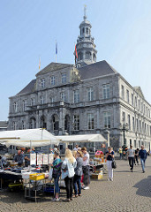 Flohmarkt / Marktstände auf dem Rathausplatz in Maastricht; das Rathaus / Stadhuis wurde 1684 fertig gestellt.
