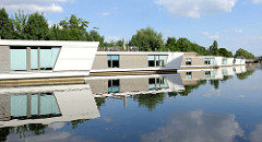 Moderne, neue Hausboote liegen am Ufer des Hochwasserbassins in Hamburg Hammerbrook.