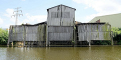 Altes Holzlagerhaus mit überdachtem Liegeplatz für die Frachtschiffe / Binnenschiffe, damit die Ladung im Trockenen gelöscht werden kann.