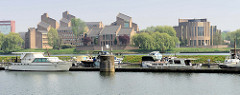 Sportboote / Motorboote liegen in einer Marina eines alten Hafenbecken an der Maas bei Maastricht; im Hintergrund das Gouvernement der Stadt - dort wurde 1992 der Vertrag von Maastricht unterzeichnet.