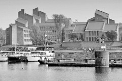Sportboote / Motorboote liegen in einer Marina eines alten Hafenbecken an der Maas bei Maastricht; im Hintergrund das Gouvernement der Stadt - dort wurde 1992 der Vertrag von Maastricht unterzeichnet.