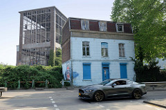 Alleinstehendes kleines, verlassenes Wohnhaus im Hafengebiet von Maastricht dahinter ein verlassenes Werftgebäude am Biesenwal iin Maastricht.