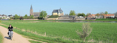 Blick über die Maas auf die Burgruine De Keverberg und die Dorfkirche von Kessel;