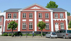 Gebäude mit Mittelrisatlit, roter Fassade mit weissen Stuckelementen - Sct Catharinae pl. in Ribe.