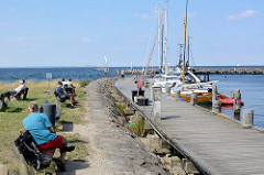 Hafenpromenade in Timmendorf auf der Insel Poel - Mecklenburg Vorpommern; Boote liegen am Steg - im Hintergrund die Hafenmole.
