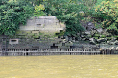 Alte Kaimauer im Moldauhafen - Kleinen Grasbrook / Hamburger Hafen; das Niedrigwasser legt das Holzfundament frei - Teile der Steinmauer sind eingestürzt.