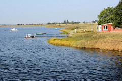 Urlaubsidylle auf der Insel Poel - Mecklenburg Vorpommern. Boote liegen am Steg - Holzhütte am Wasser.