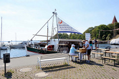 Fischverkauf vom Kutter am Hafen von Kirchdorf auf der  Insel Poel - Mecklenburg Vorpommern; im Hintergrund die Spitze vom Kirchturm der