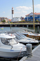 Sportboothafen in Timmendorf auf der Insel Poel - Mecklenburg Vorpommern; Boote liegen am Steg - im Hintergrund der Leuchtturm.