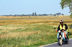 Wiesen auf der Insel Poel - Mecklenburg Vorpommern; Motorradfahrter in Fahrt.