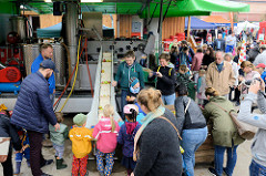 Eine mobile Apfelsaft Pressmaschine / Mosterei wird auf dem Apfel- und Kartoffelfest  vom Gut Wulksfelde den Besuchern vorgeführt; Kinder können die Äpfel auf ein Förderband legen.
