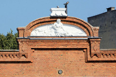 Giebel eines Backsteingebäudes Stettiner Hafen mit Stuckrelief.