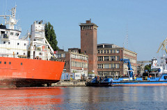 Hafen von Stettin, Verwaltungsgebäude mit Backstein-Uhrenturm, Fracht- und Arbeitsschiffe.