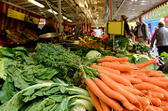 Marktstand auf dem Wochenmarkt  in Hamburg Sasel -  Stand mit Obst und Gemüse; Möhren / Karotten / Wurzeln.