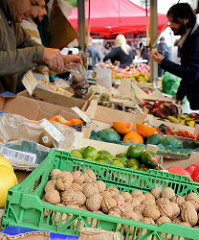 Wochenmarkt im Hamburger Stadtteil Eimsbüttel / Grundstraße - Marktstand mit Obst und Gemüse, im Vordergrund frisch geerntete Walnüsse.