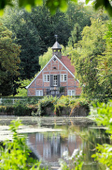 Blick über den Mühlenteich zur ehem. Kupfermühle im Hamburger Stadtteil Wohldorf-Ohlstedt. Das restaurierte Gebäude wurde 1827 errichtet.